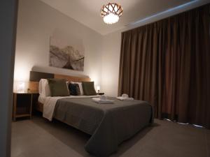 a bedroom with a bed and a chandelier at C&A Luxury Apartment in Igoumenitsa