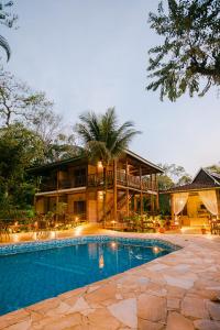 una casa con piscina frente a ella en Pousada Maná, en Boicucanga