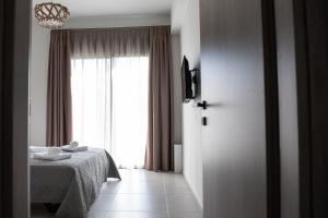a bedroom with a bed and a large window at C&A Luxury Apartment in Igoumenitsa