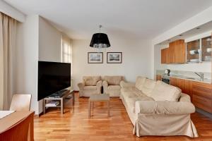 a living room with a couch and a flat screen tv at Grand Apartments - Willa Morska Premium in Sopot