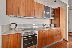 a kitchen with wooden cabinets and stainless steel appliances at Grand Apartments - Willa Morska Premium in Sopot