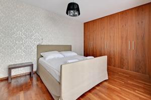 a bedroom with a bed and wooden cabinets at Grand Apartments - Willa Morska Premium in Sopot