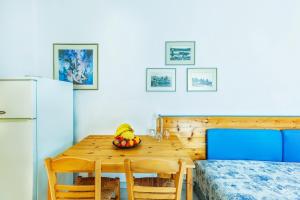 a kitchen with a wooden table with a bowl of fruit at Xenios Faros Apartments in Possidi