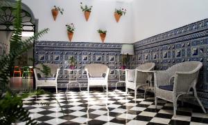 una stanza con sedie e un tavolo su un pavimento a scacchi di La Central Sevilla a Siviglia