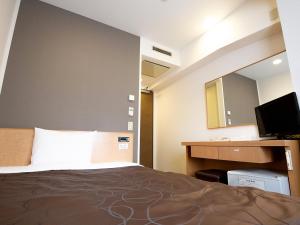 a hotel room with a bed and a mirror at Swanky Hotel Otomo in Sapporo