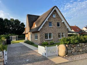 a brick house with a white fence in front of it at Bi de Kühlung in Rerik