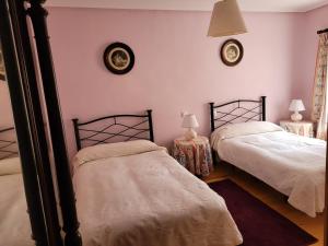 duas camas num quarto com duas mesas e dois relógios em Apartamentos Puente Viesgo Viviendas Rurales em Puente Viesgo