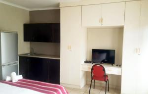 a bedroom with a bed and a red chair at Self-catering 1Bedr cottage in Sandton with FREE WiFi in Johannesburg