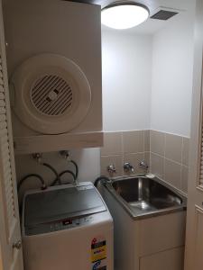 a small kitchen with a sink next to a sink at Chatswood Hotel Apartment in Sydney