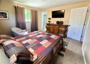 a bedroom with a bed and a flat screen tv at Cottonwood Comfort in Salt Lake City