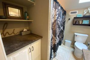 a bathroom with a toilet and a shower curtain at Cabernet Cottage in Cottonwood