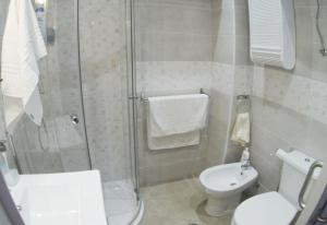a bathroom with a toilet and a glass shower at Alexa House in Costa de Antigua +18 photos