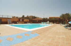 a large swimming pool in a resort with palm trees at Alexa House in Costa de Antigua
