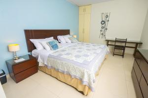 ein Schlafzimmer mit einem großen Bett und einem Nachttisch in der Unterkunft Posada Blanca Hotel Boutique in Piura