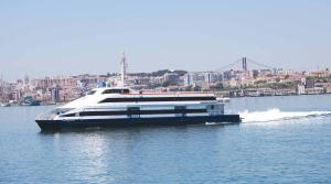 a large boat on the water with a city in the background at Residencial Principe Guest House in Barreiro