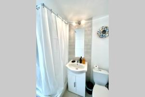 La salle de bains blanche est pourvue de toilettes et d'un lavabo. dans l'établissement Chambre indépendante chez l'habitant, à Nîmes
