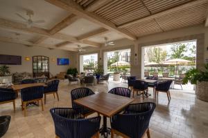 a restaurant with tables and chairs and windows at Hermoso depto con alberca en el condo La Luminaria Casonas y Villas in San Miguel de Allende