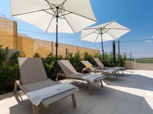 a group of chairs and umbrellas on a patio at Holiday home in Mekisi kod Vizinade - Istrien 41755 in Ferenci