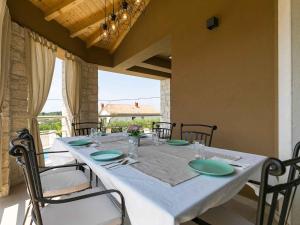 a table with chairs and a white tablecloth on it at Holiday home in Mekisi kod Vizinade - Istrien 41755 in Ferenci