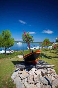 un barco sentado sobre un montón de rocas en Apartments in Klimno, Dobrinj - Insel Krk 41812, en Klimno 9 fotos más