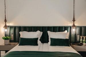 a bedroom with a bed with green and white pillows at The Berg's 4 in Ocna-Mureşului