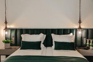 a bedroom with a bed with green and white pillows at The Berg's 4 in Ocna-Mureşului +2 photos