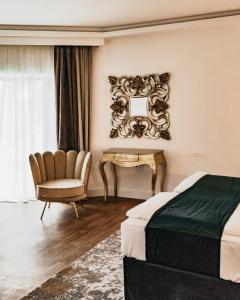 a bedroom with a bed and a chair and a mirror at The Berg's 4 in Ocna-Mureşului