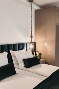 a bedroom with a large white bed with black and white pillows at The Berg's 4 in Ocna-Mureşului