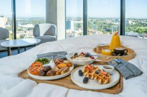 a tray of food on a bed with plates of food at Crowne Plaza Adelaide, an IHG Hotel in Adelaide