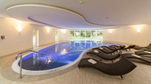 a large swimming pool in a building at Dorint Herrenkrug Parkhotel Magdeburg in Magdeburg