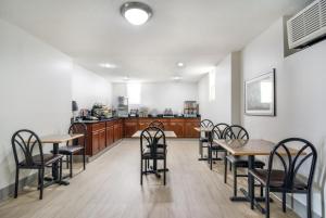 a dining room with tables and chairs and a kitchen at The Townhouse Inn in High Point