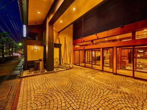 加賀的住宿－Yukai Resort Saichoraku，前面有铺着瓷砖的人行道的建筑