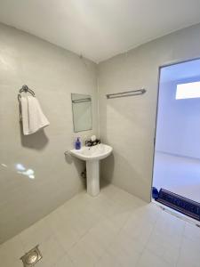 a white bathroom with a sink and a mirror at Desert Dune Farmhouse - By Seven Elements in Ras al Khaimah