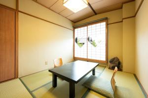 uma sala de jantar com uma mesa e uma janela em Yamadaya Ryokan em Quioto