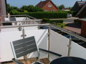 a balcony with a chair on a boat at Hotel Thule in Carolinensiel