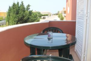 a table on a balcony with a glass on it at Casa Dos Cedros in Lagos