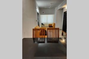 sala de estar con mesa y sillas en una habitación en BMRAN Apartment A en Ernakulam