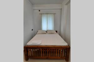 Cama en habitación pequeña con ventana en BMRAN Apartment A en Ernakulam