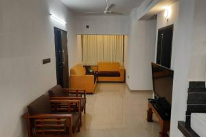 sala de estar con sofá y sillas en BMRAN Apartment A en Ernakulam
