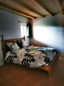 a bedroom with a bed with a comforter and a window at Case Lénaron in Saint-Joseph