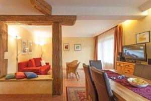 ein Wohnzimmer mit einem roten Sofa und einem Esszimmer in der Unterkunft Amadeus Appartement in Sankt Johann in Tirol