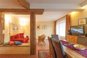 a living room with a red couch and a dining room at Amadeus Appartement in Sankt Johann in Tirol