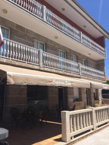 a building with a balcony on top of it at Hostal Eden in Sanxenxo