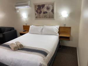 En eller flere senge i et værelse på All Settlers Motor Inn Parkes