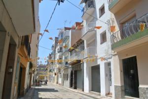 an alley in the city with flags hanging from buildings at Aiguaneu S'Auguer in Blanes