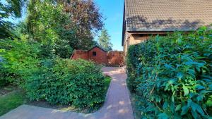 um caminho de tijolos que leva a uma casa com um edifício em Ferienwohnung in Osterdeichstrich em Oesterdeichstrich