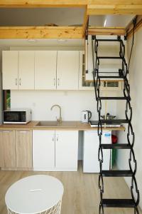 una cocina con armarios blancos y una escalera de caracol en una habitación en Polana Glamp, 