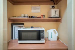 a microwave sitting on a shelf next to a toaster at Winter Sun Motel in Rockhampton