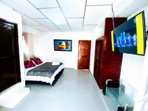1 dormitorio con 1 cama y TV de pantalla plana en LA Perla Sabanera CTG en Cartagena de Indias