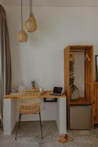 a desk with a laptop and a chair in a room at Tiga Studios - Adults Only in Kuta Lombok